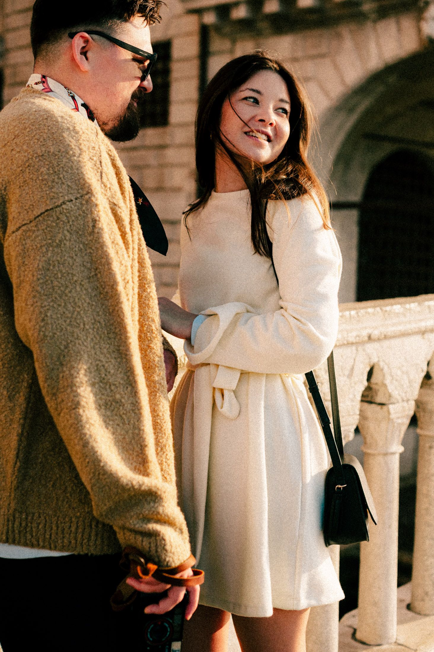 Couple sharing a moment together under Venice's historic arches.