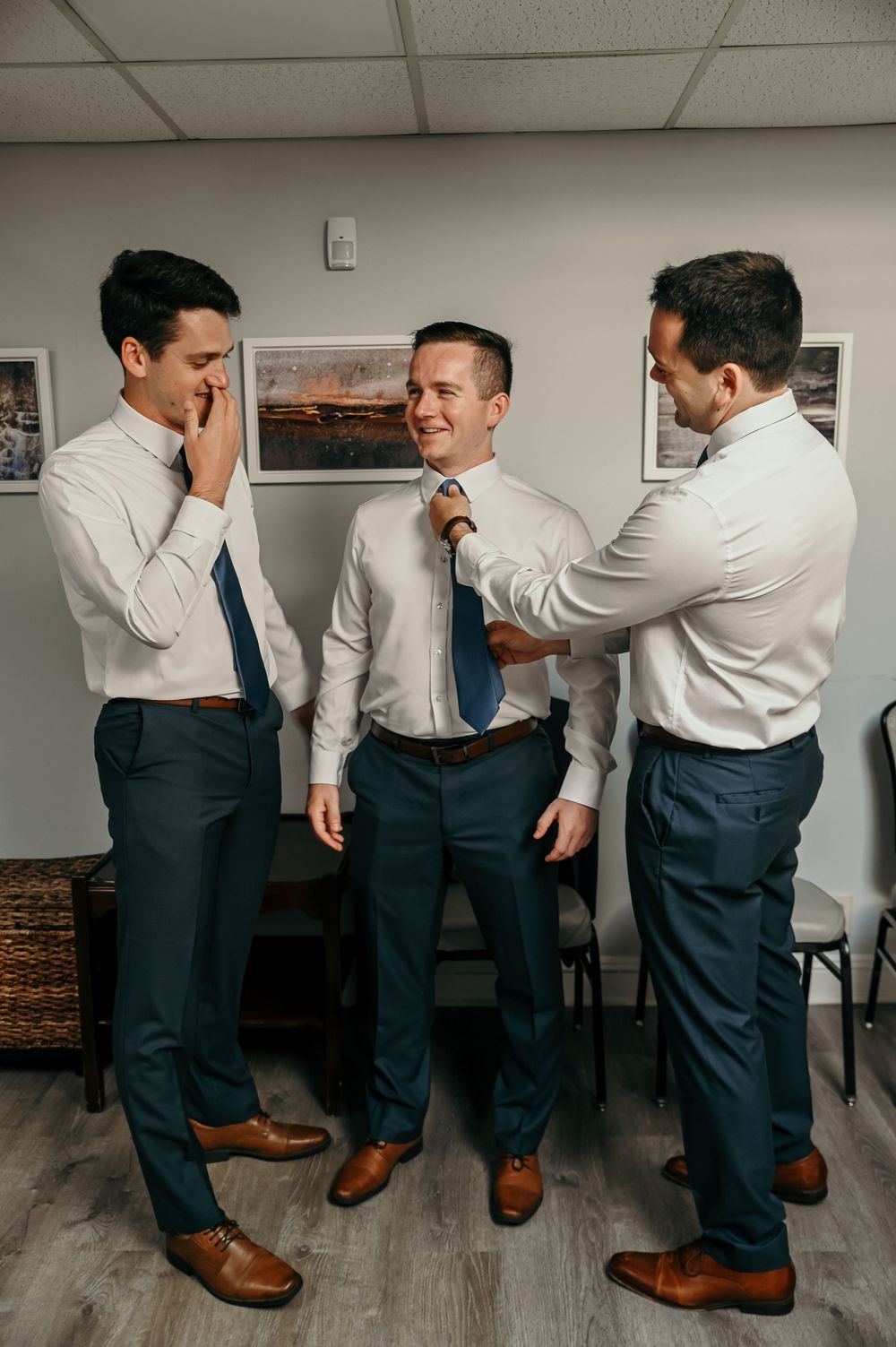 Candid moments of groomsmen preparing and joking around before the ceremony.