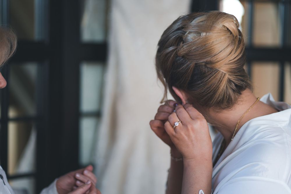 Behind the scenes of wedding preparation as stylist works on hair.