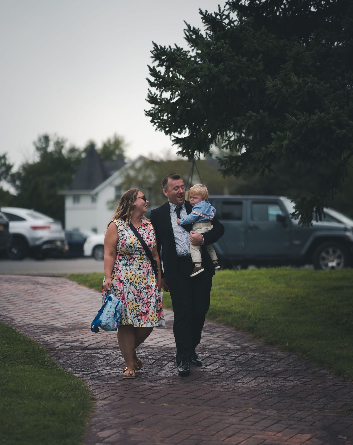 Wedding party walking on grass with members wearing emerald green dresses.