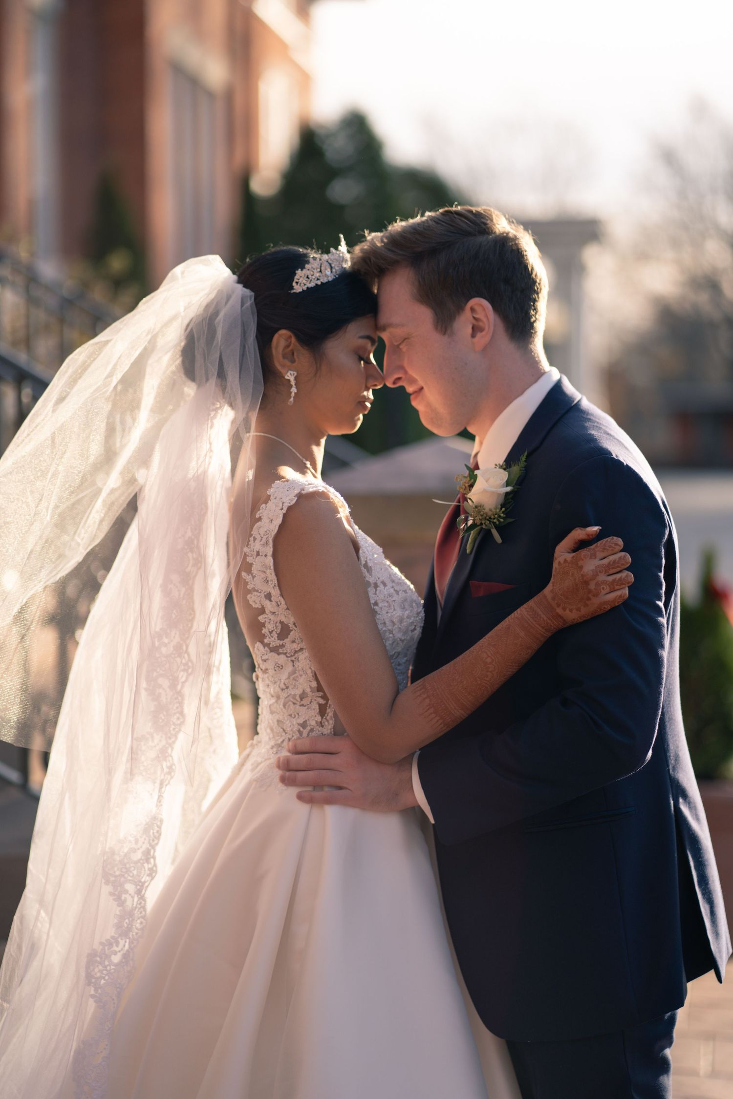 A tender wedding embrace backlit by golden afternoon light.