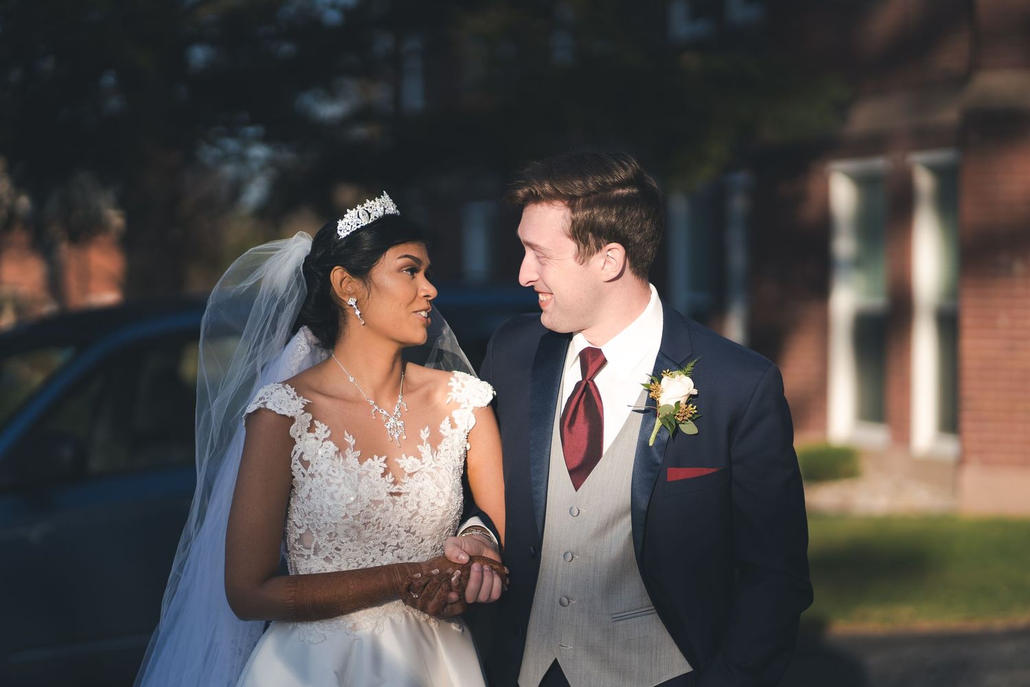 A joyful wedding moment captured outdoors with classic architecture in background.