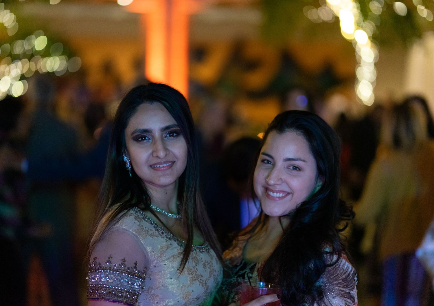 Wedding reception guests in colorful traditional Indian attire at an evening celebration.