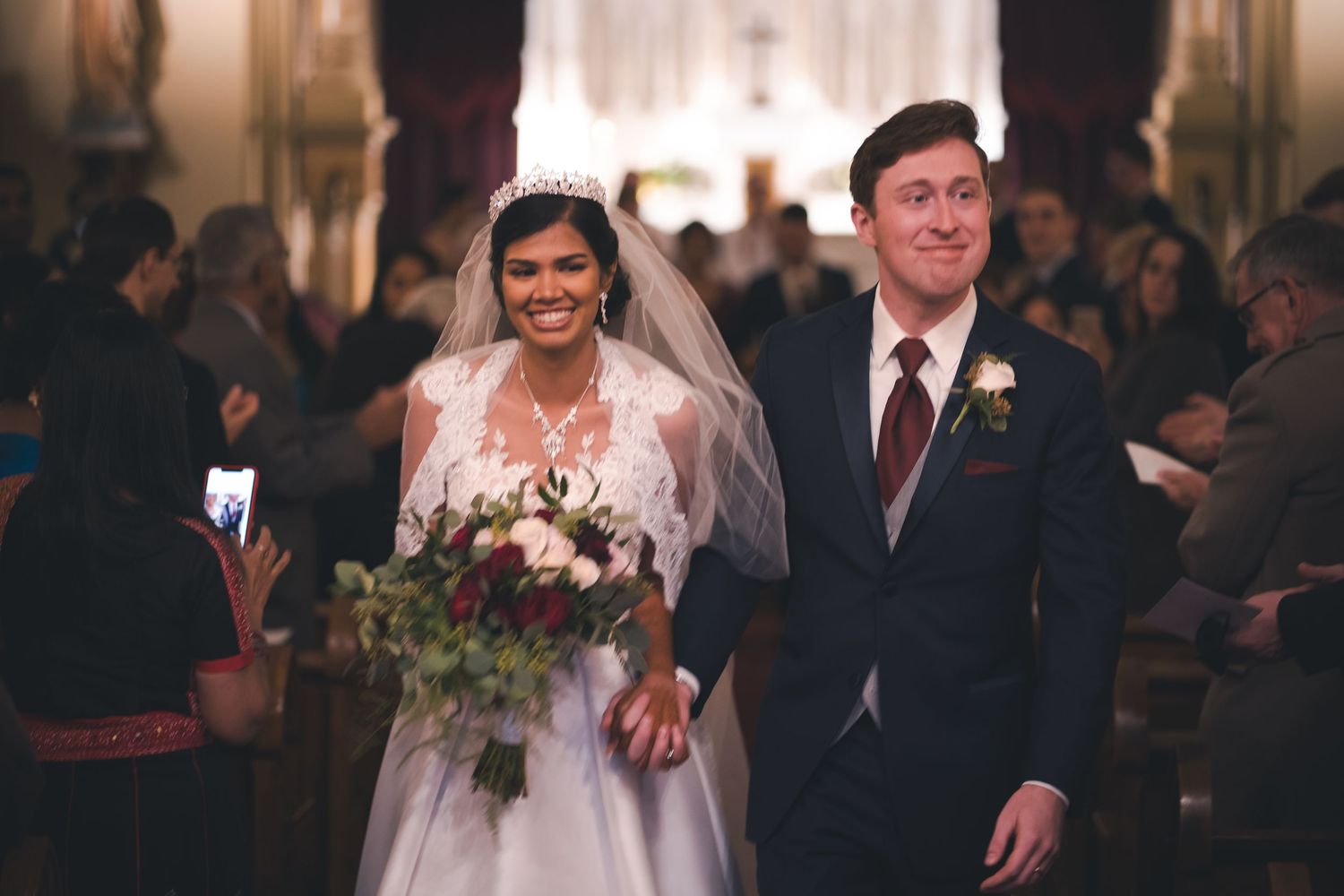 A joyful couple walking down the church aisle after their wedding ceremony.
