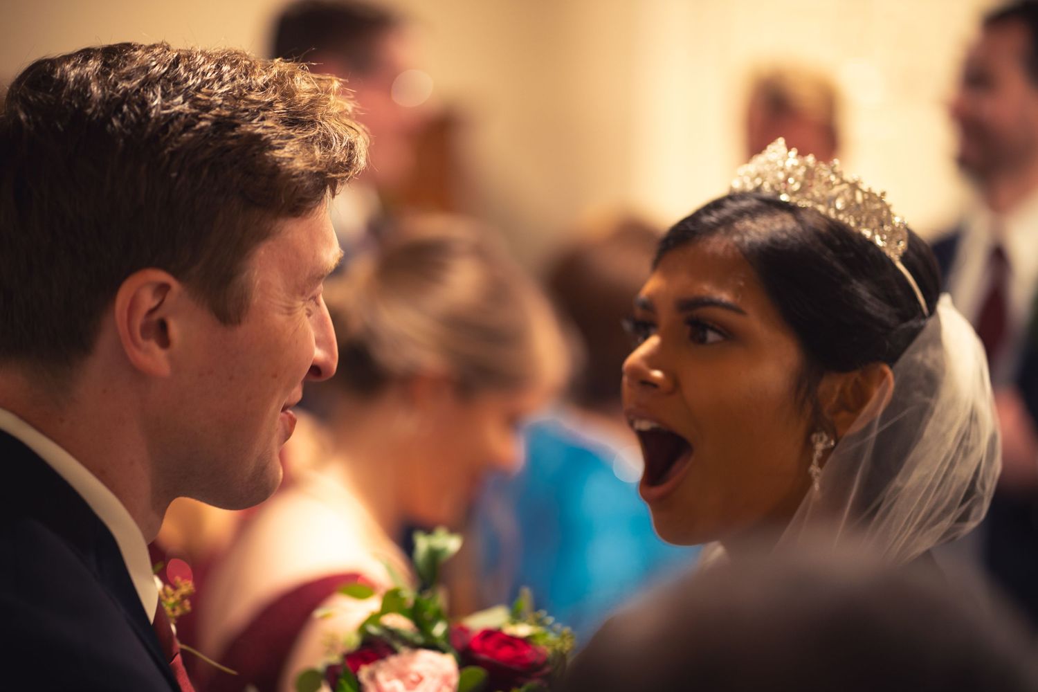 A candid moment captured between a bride and groom sharing a joyful expression during their wedding celebration.