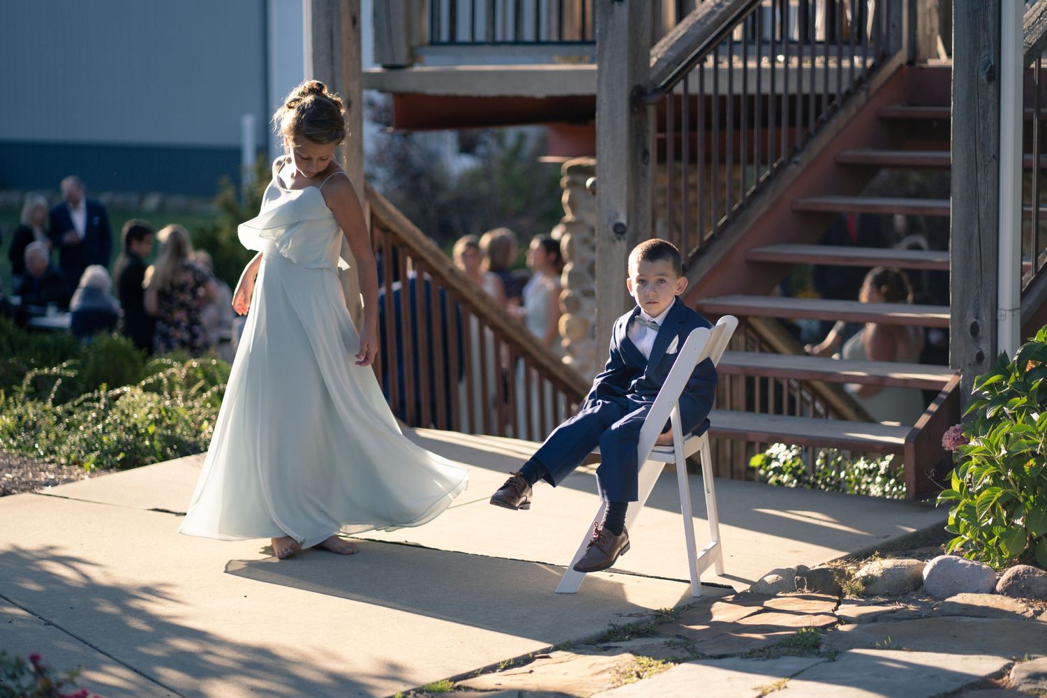 A playful dance moment during a wedding near wooden stairs outdoors.