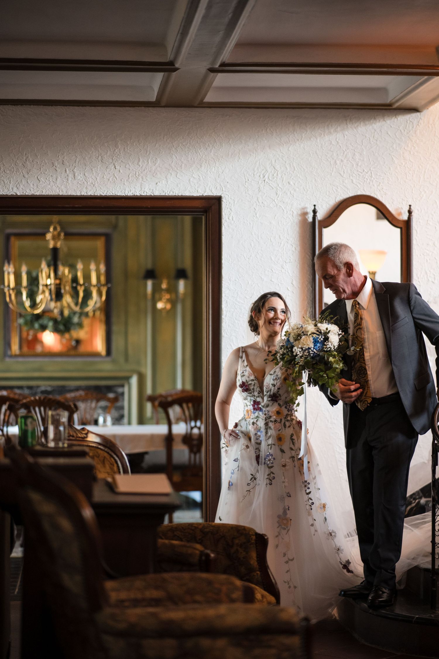 An elegant wedding scene in a vintage-style room with chandelier reflections.