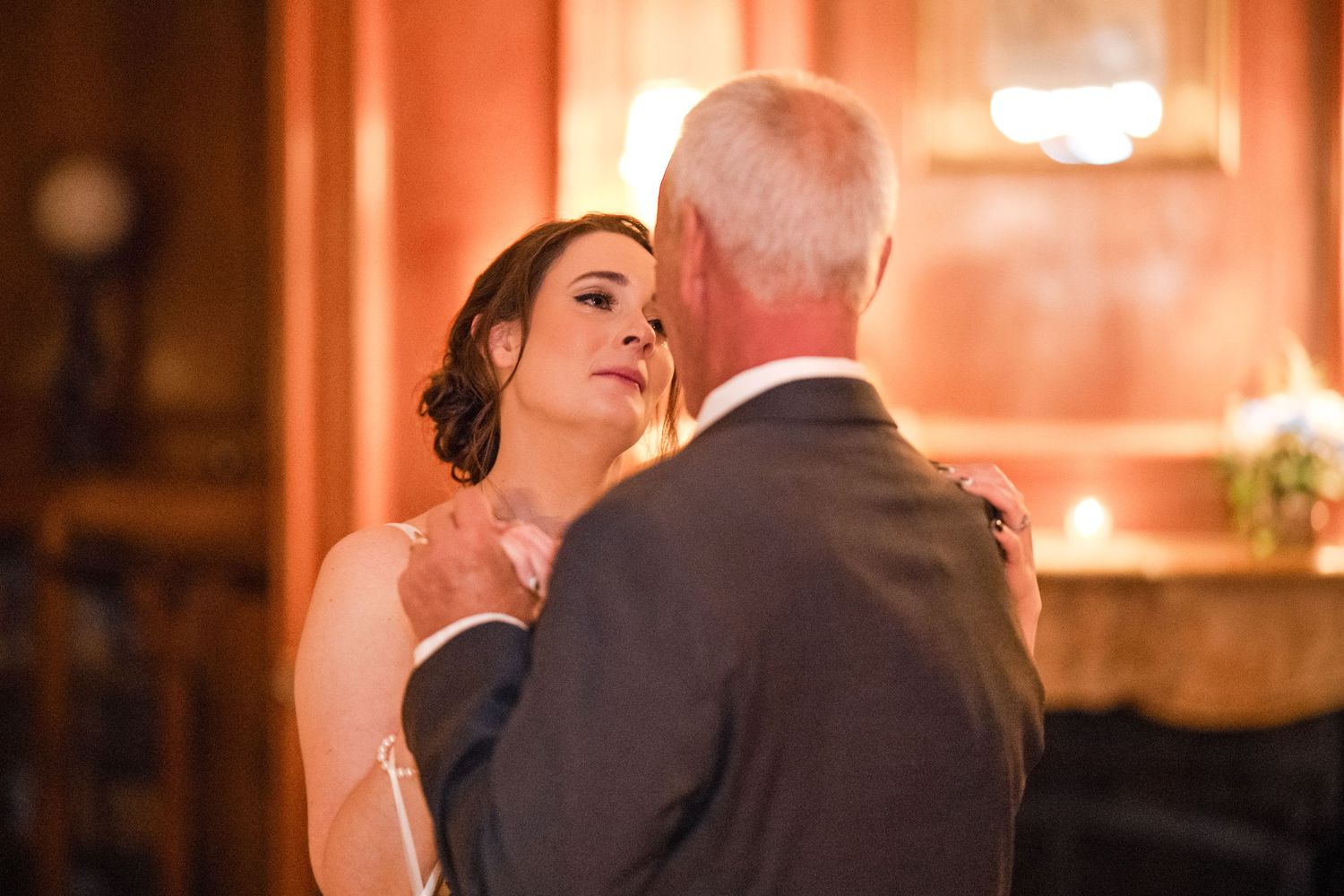 A tender moment during a wedding dance in warm ambient lighting.