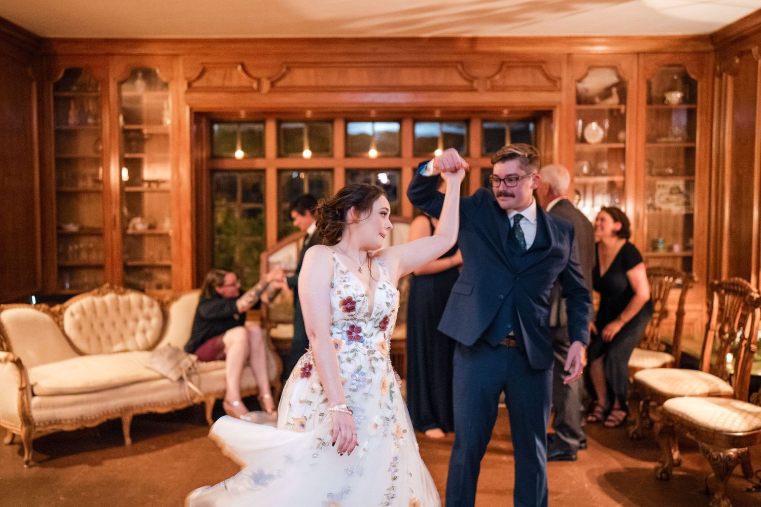 A celebratory dance moment at an elegant wedding reception with wooden decor.