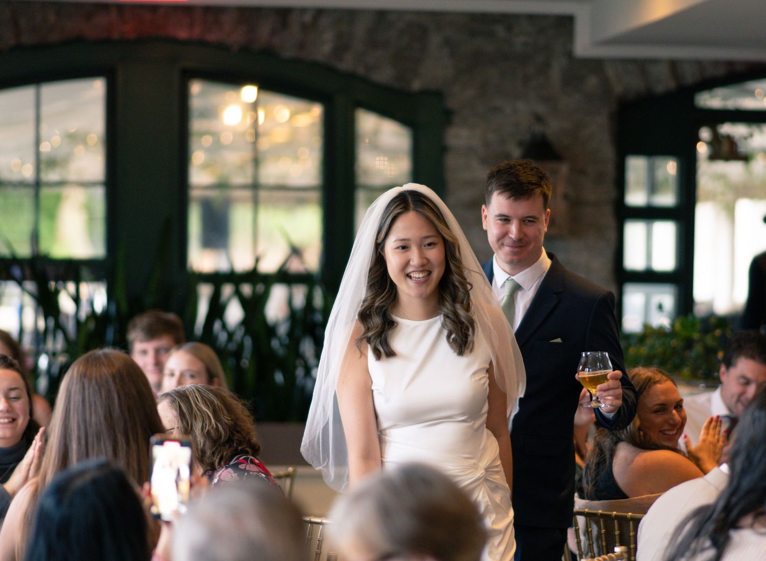 A smiling bride and groom during their indoor wedding celebration.