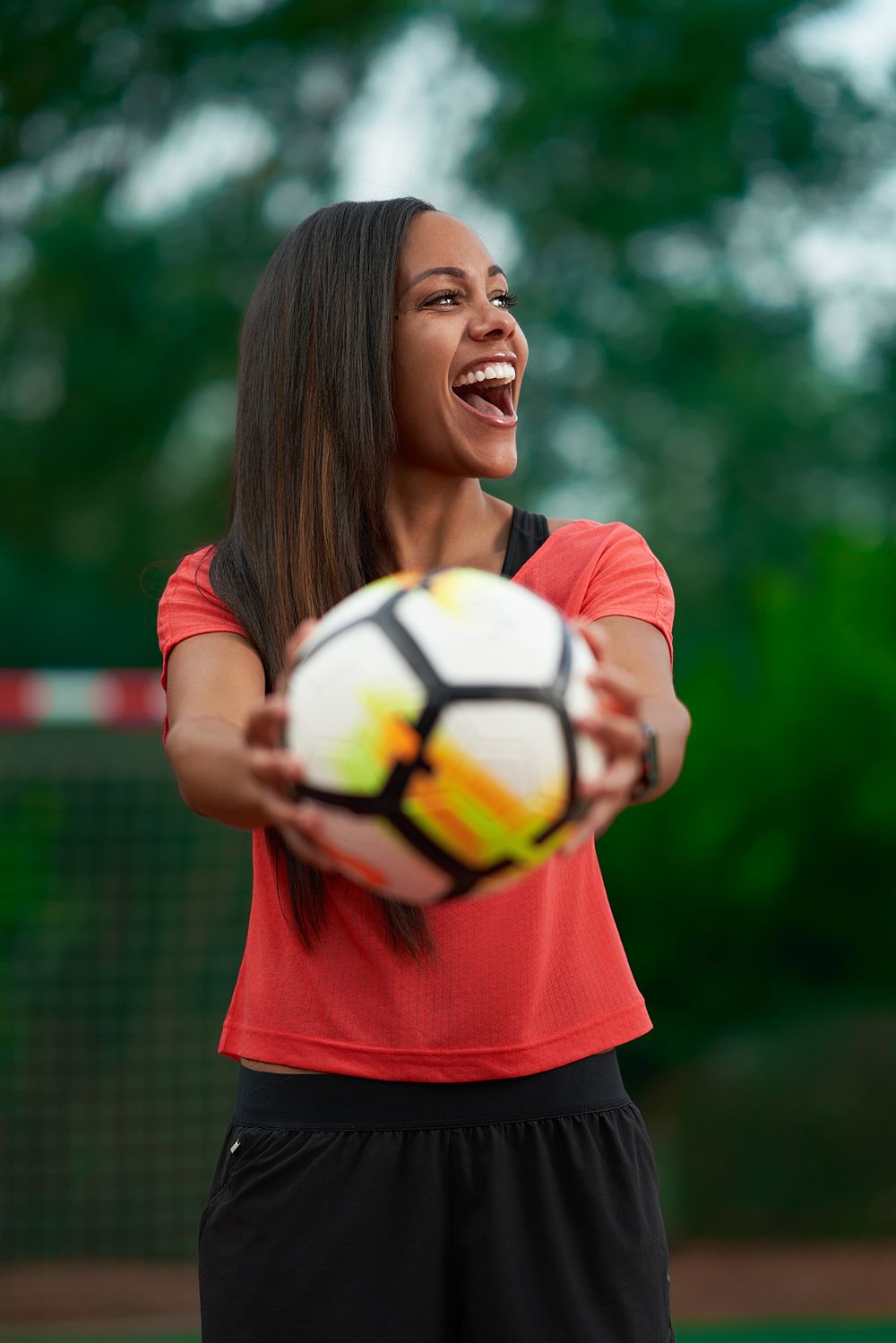 Alex Scott holding a football and laughing