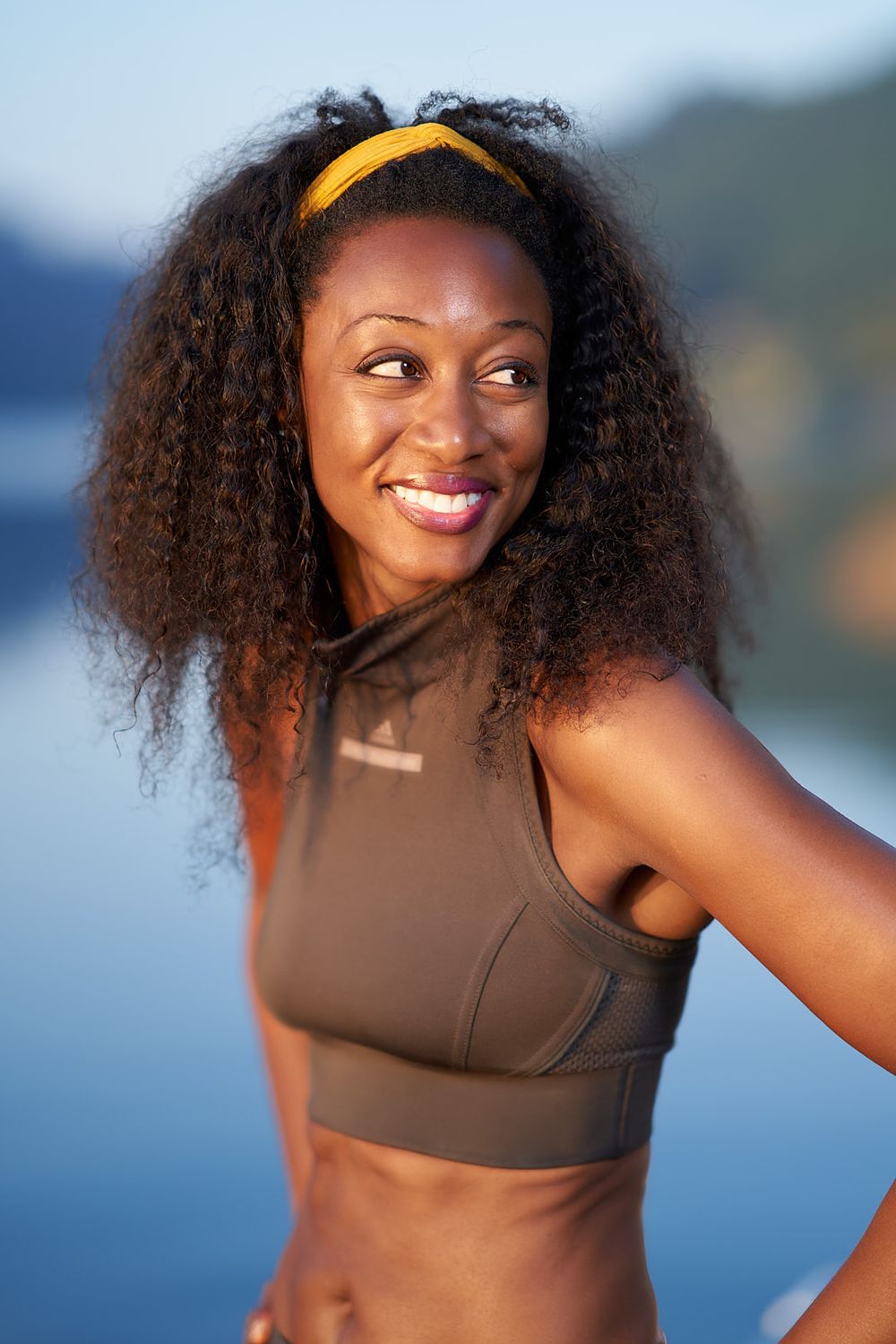Beverley Knight standing in front of a lake in Portugal smiling and looking away from camera