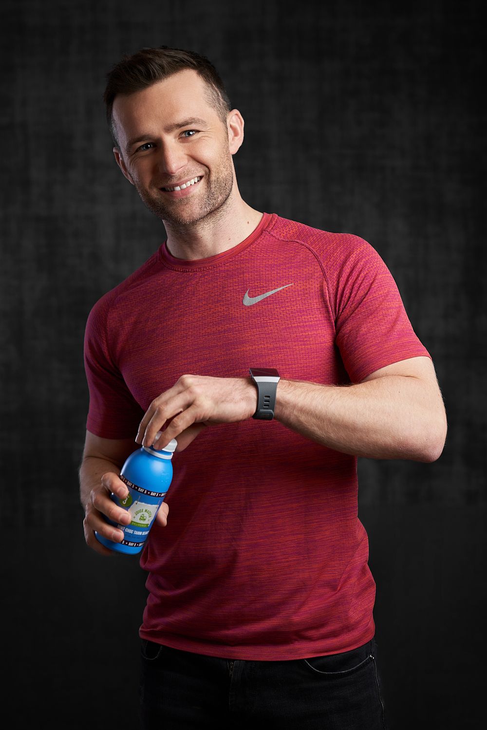 Harry Judd standing with a bottle of juice