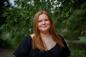 Portrait of young woman with red hair, smiling green background