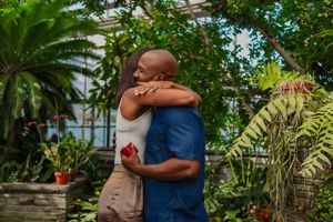 Couple hugging after man proposed in greenhouse