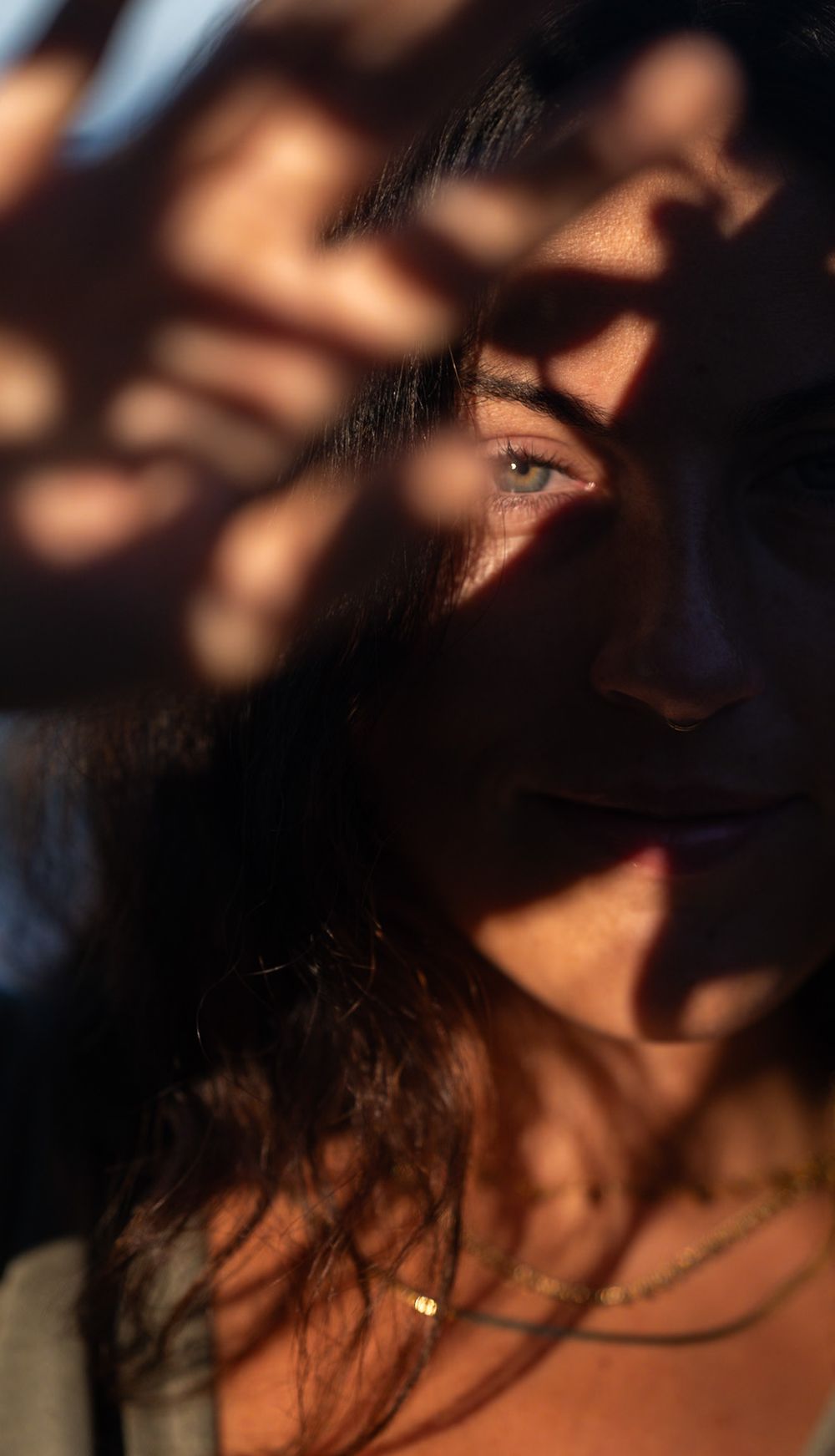 Artistic portrait with dramatic shadow patterns creating a moody aesthetic.