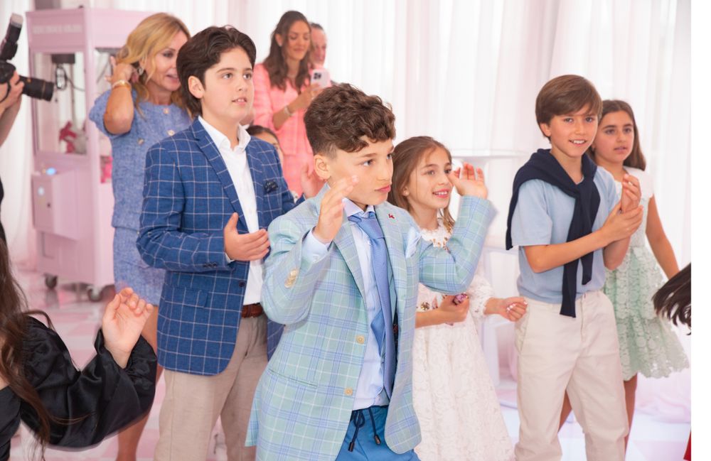 People dancing and celebrating in formal attire at an elegant indoor party.