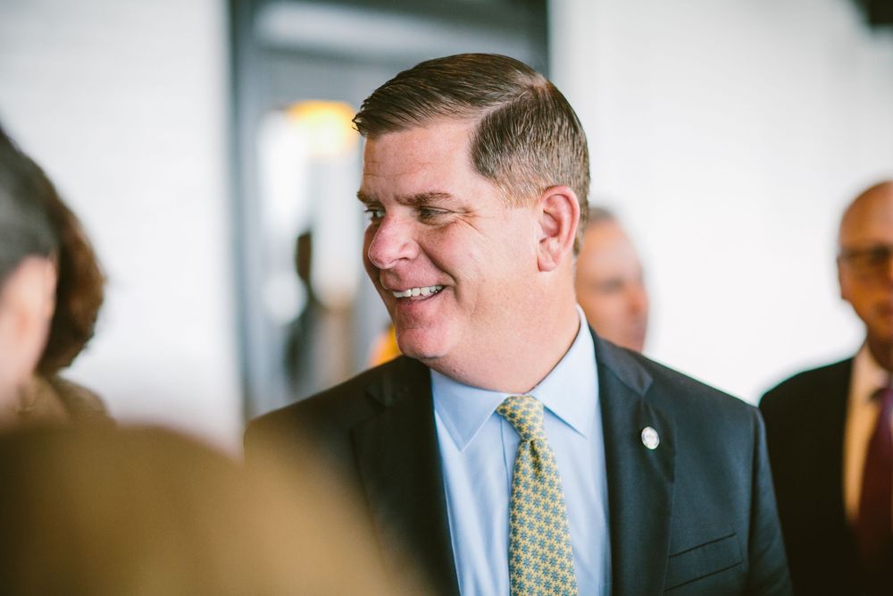 Professional in navy suit and yellow polka dot tie smiles warmly during business gathering.