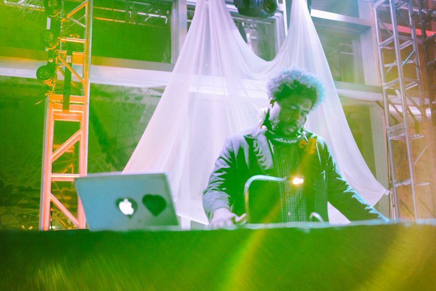 Concert performer silhouetted on stage with dramatic lighting and white fabric backdrop during live performance.