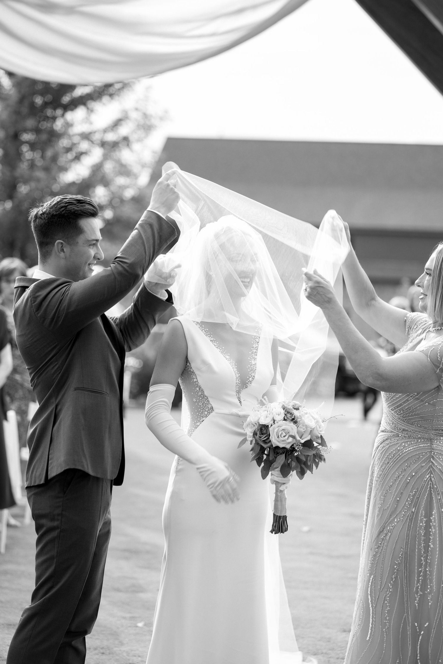 brides mom and brother remove the veil from brides face during ceremony at rochester mn wedding