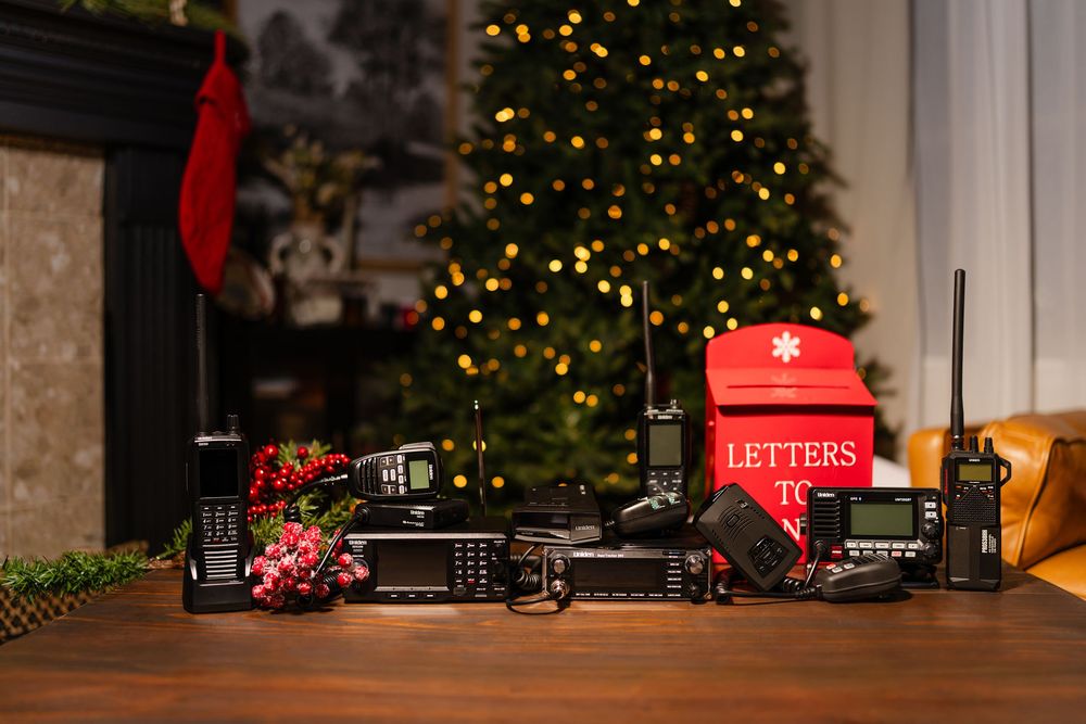 A cozy Christmas scene with a red mailbox for letters to Santa next to a decorated tree and glowing lights.