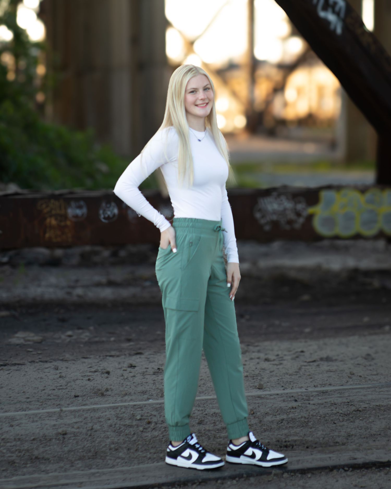 Casual outdoor fashion poses against an urban backdrop at sunset.