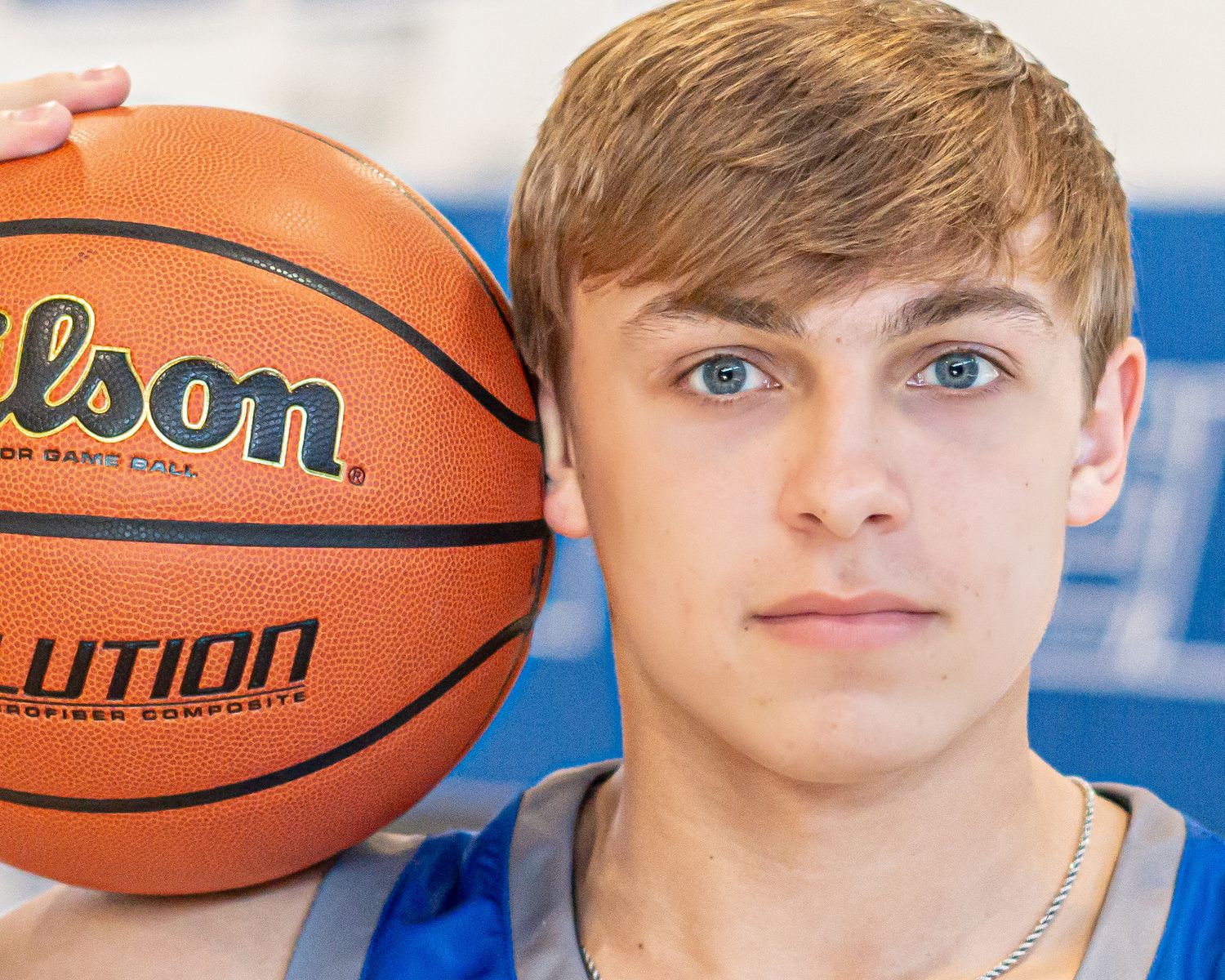 Basketball player portraits against blue background with Wilson basketballs.