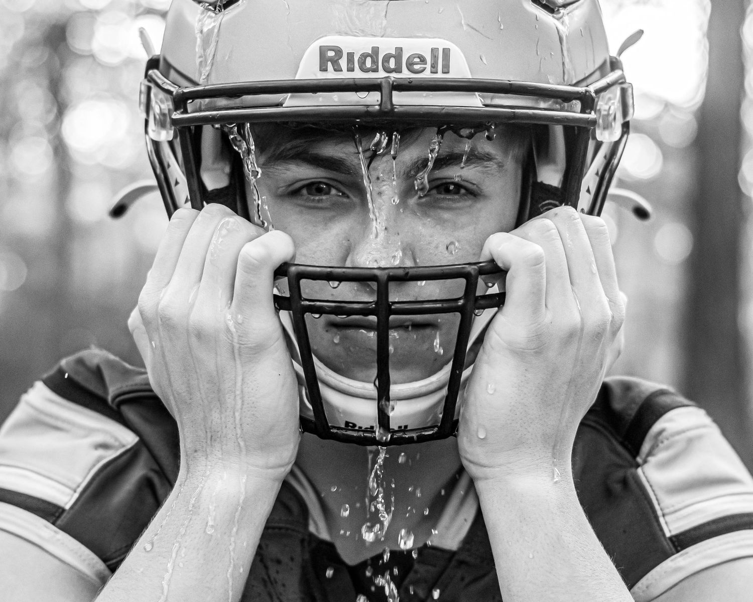 Close-up shots of Riddell football helmets being put on.