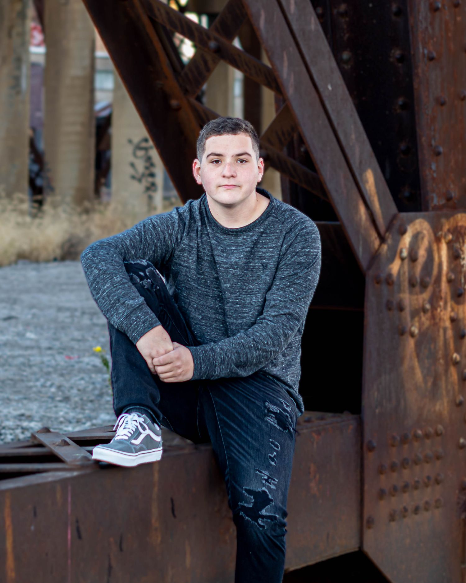 Portrait session on industrial bridge with rustic metal beams.