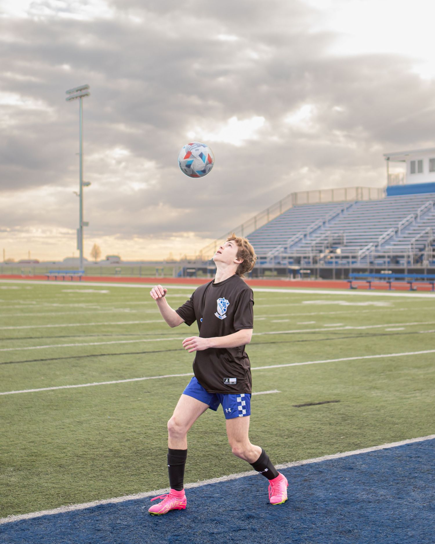 Soccer practice sequence on field with stadium bleachers in background at dusk.