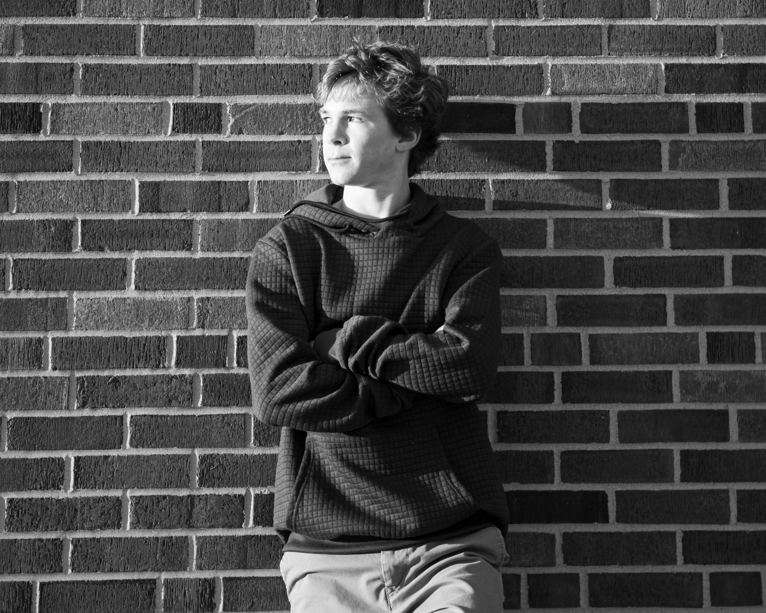 Black and white portrait series against brick wall background.