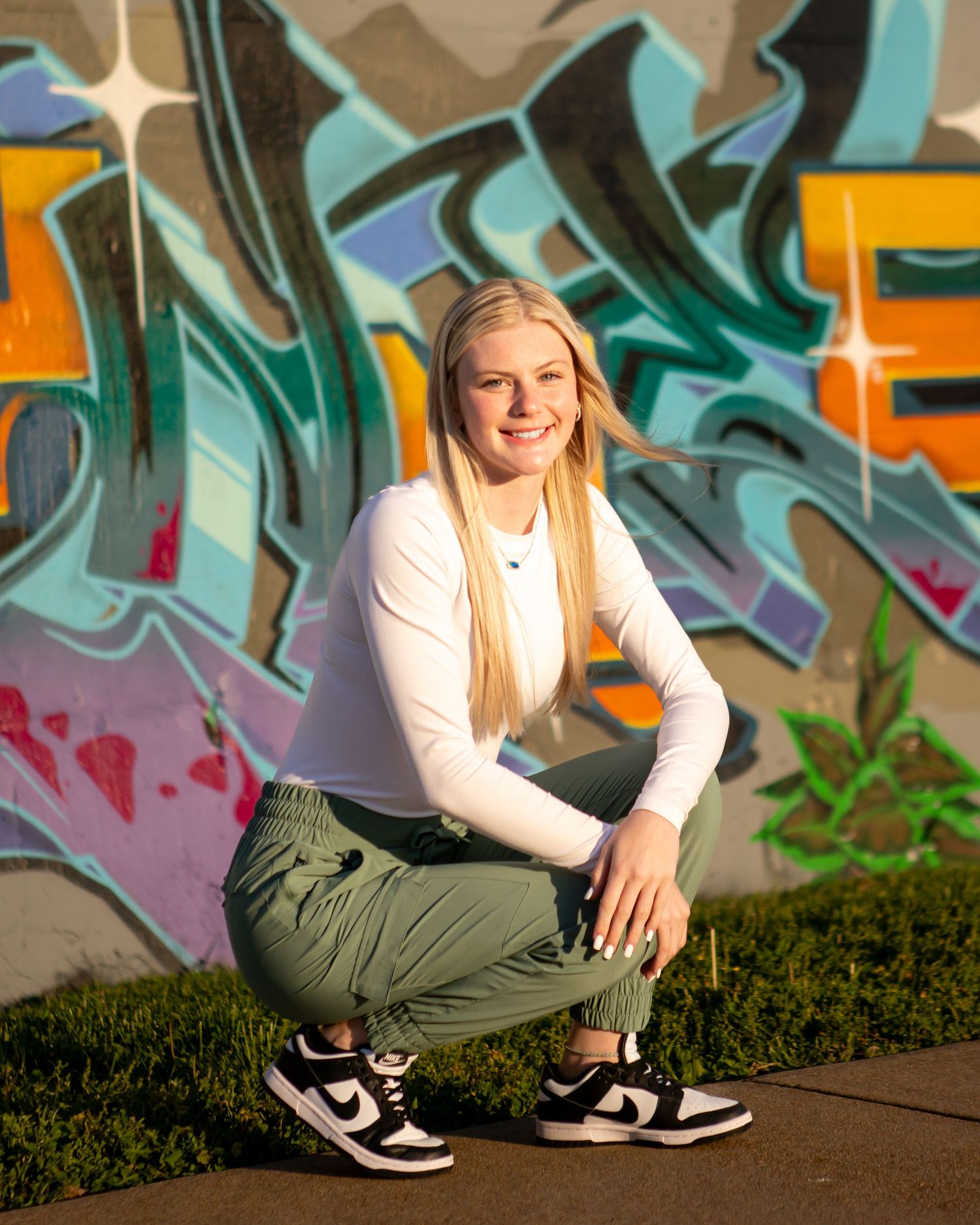 Casual streetwear look photographed against colorful graffiti wall art.