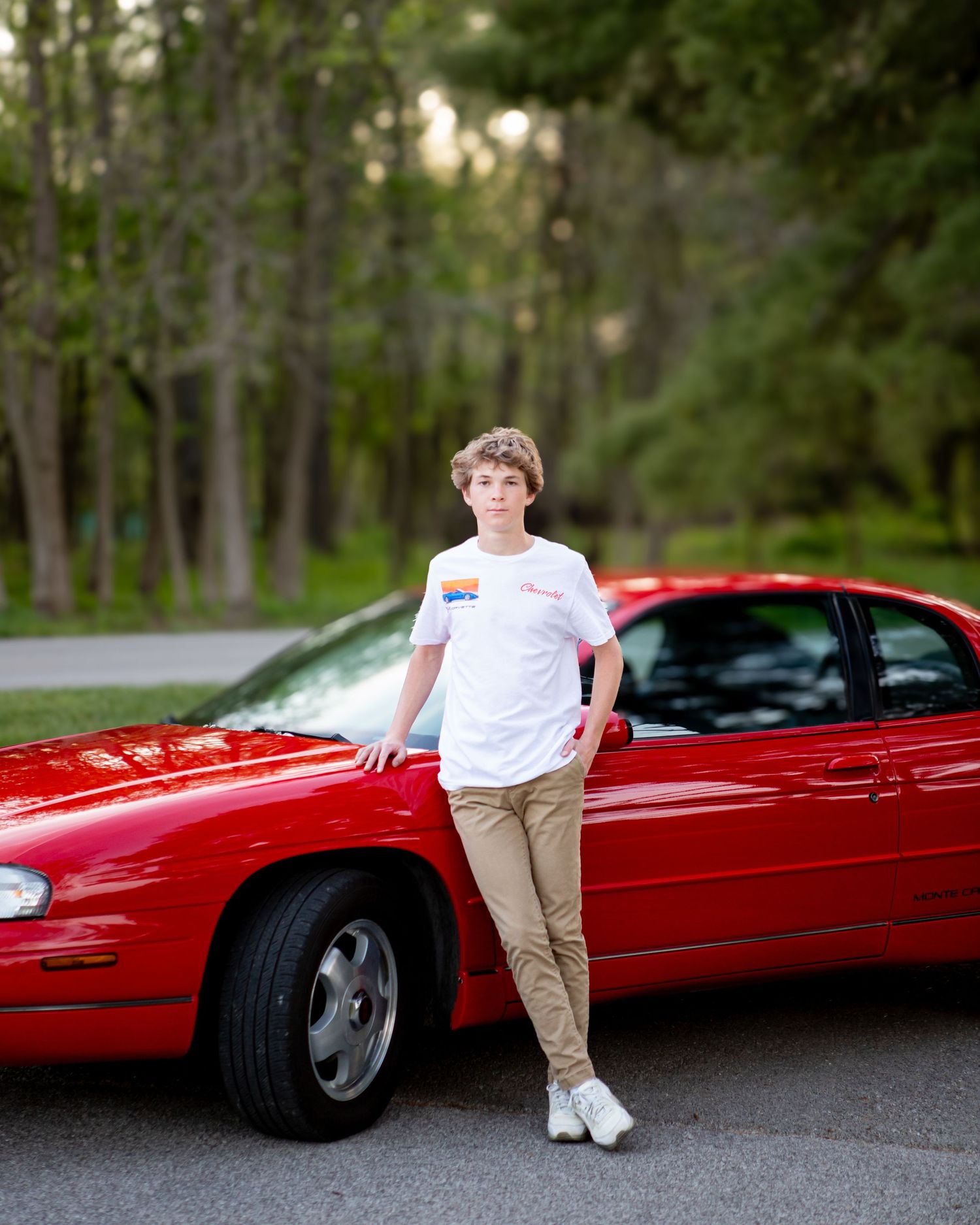 A series of photos showing someone posing with a classic red convertible car on a tree-lined road.