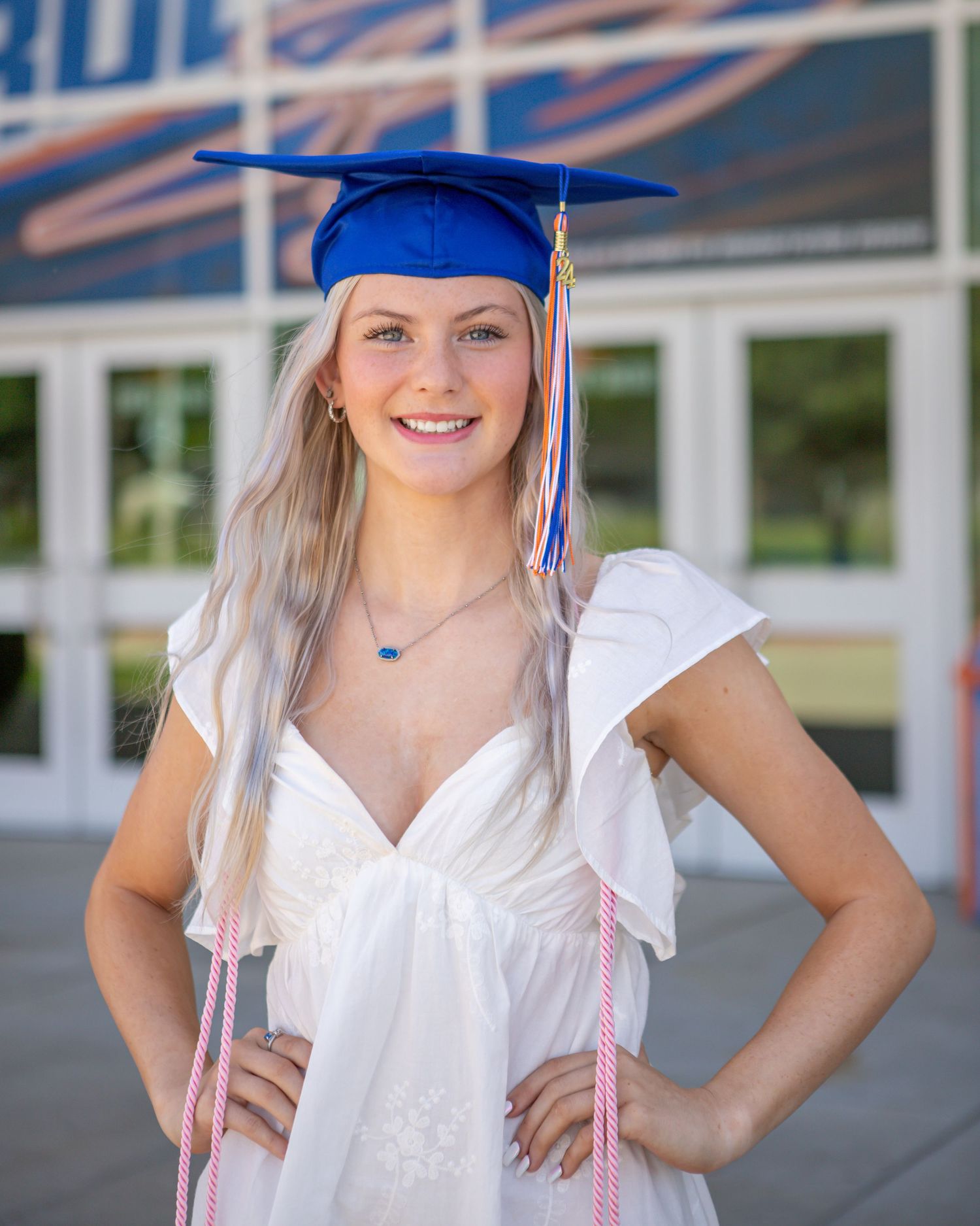 Graduation photos under blue and white striped awning.