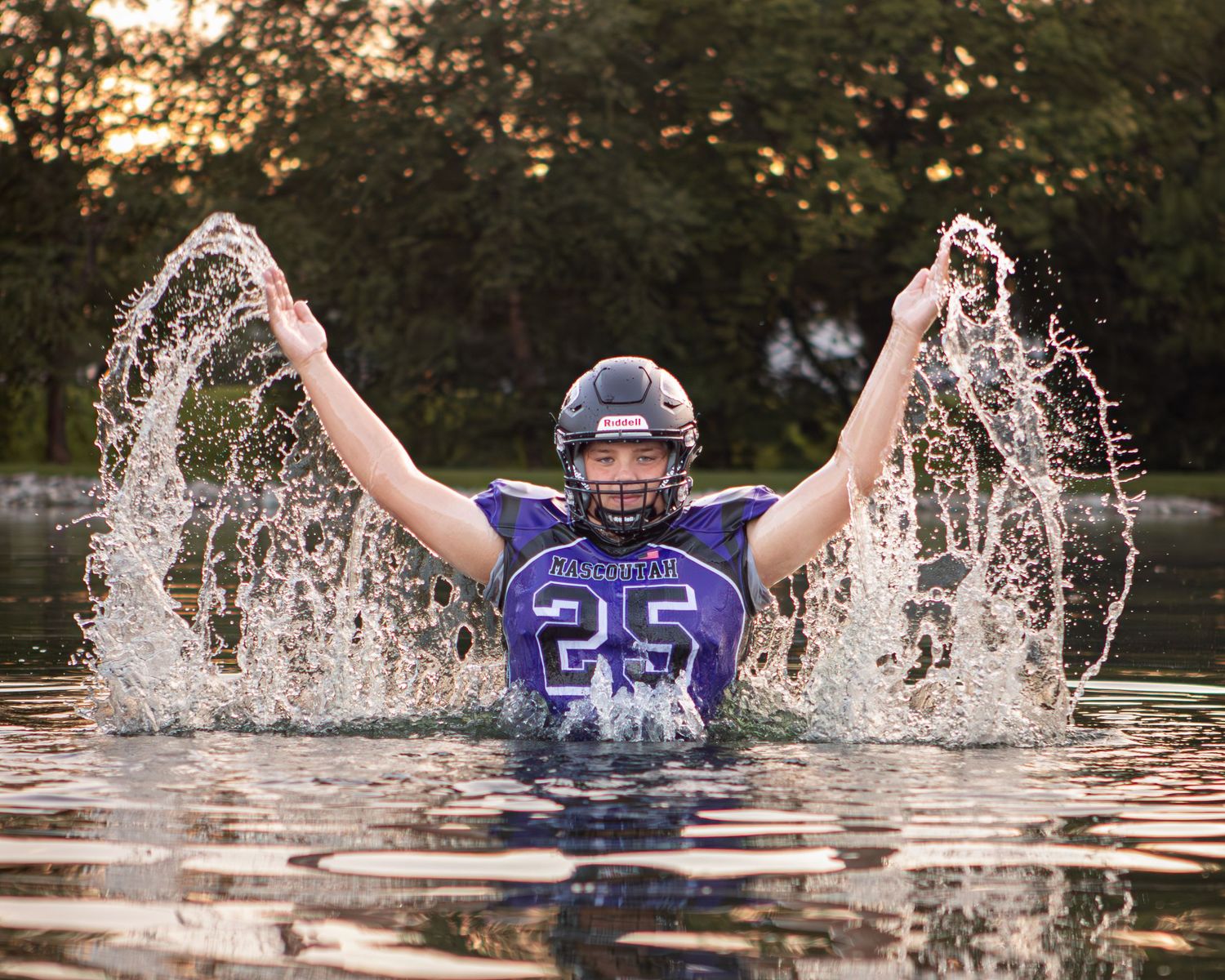 Athletic figure creating splashes in water while wearing blue sports jersey.