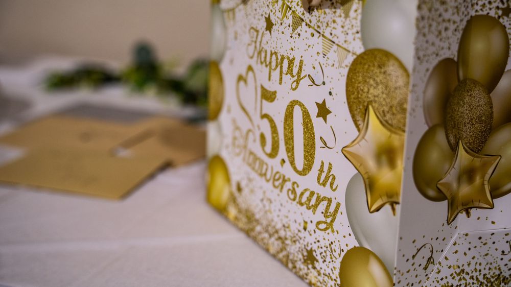 Gold anniversary decorations and balloons create an elegant celebration display.