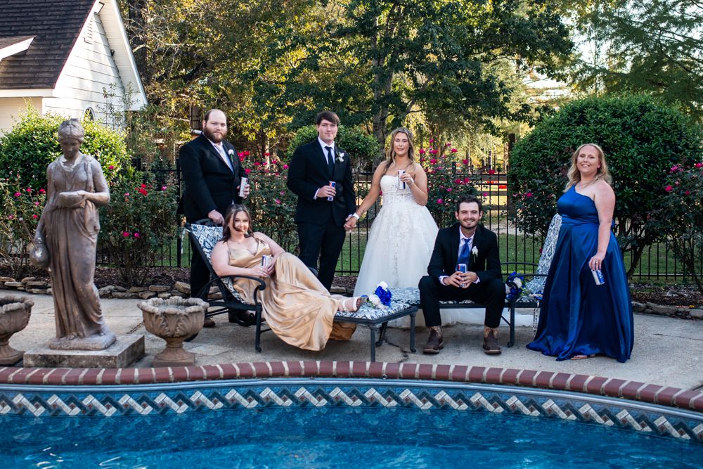 A row of five wedding party photographs at sunset taken outdoors with trees and a brick wall as the backdrop.