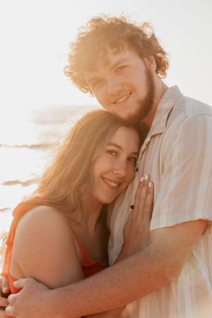 Sun-kissed couple sharing sweet moment together during golden hour beach photoshoot.