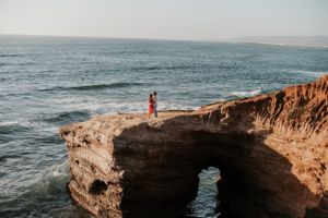 Wide angle view of a dramatic ocean coastline with rocky cliffs and crashing waves.