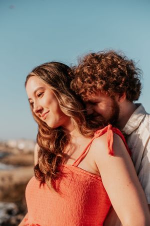 Intimate sunset photoshoot of a couple in warm lighting with orange and blue tones.