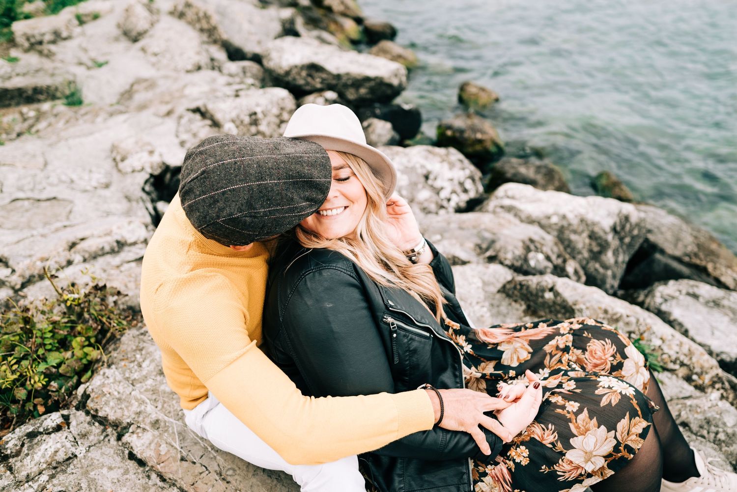 Couple kissing sitting on rocks at lake geneva in Geneva, Switzerland