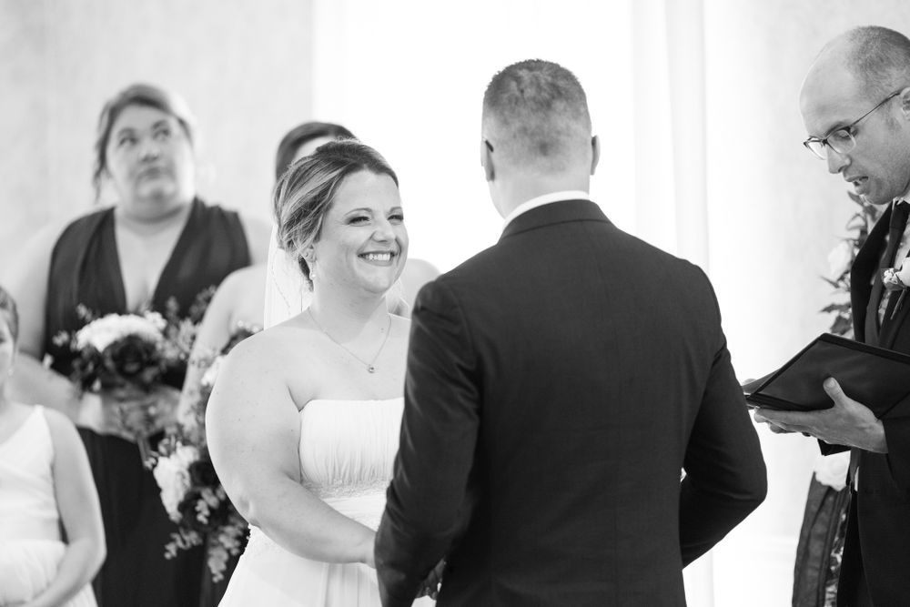 A couple exchanges vows during their wedding ceremony indoors.