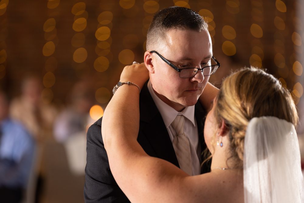 An intimate first dance moment at a wedding reception with bokeh lights in background.