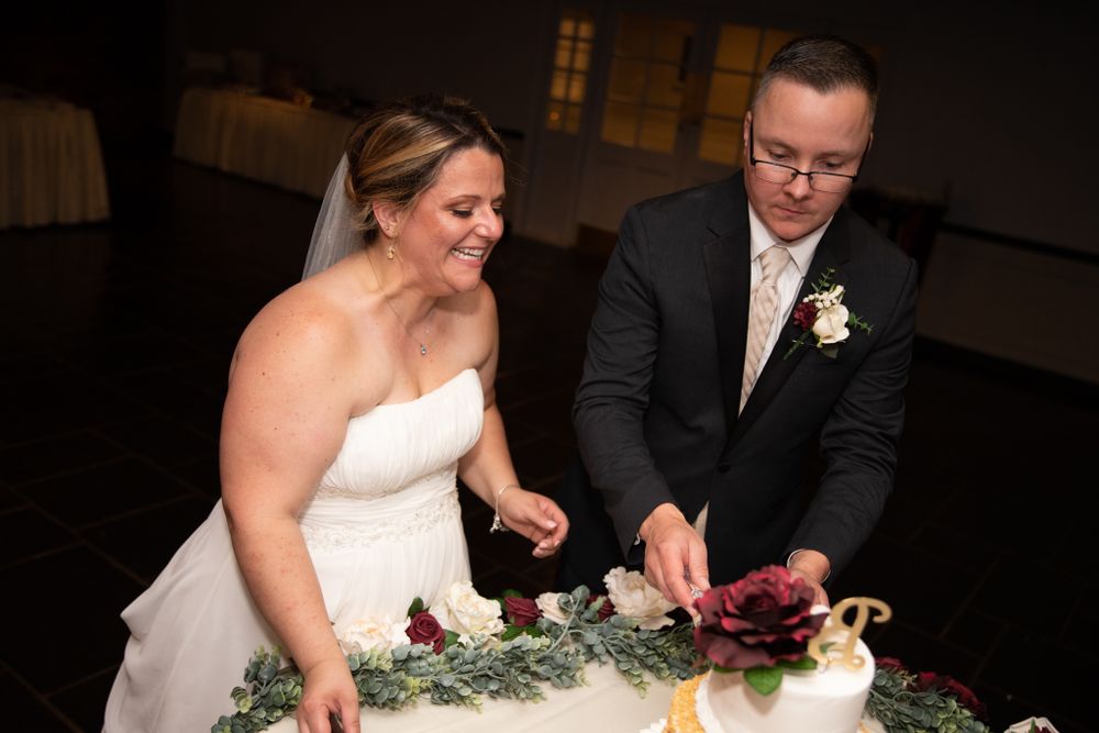 A couple cuts their wedding cake together at the reception.