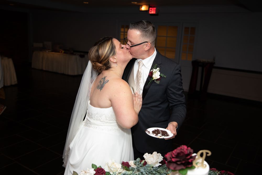 A couple shares a sweet moment while cutting their wedding cake.