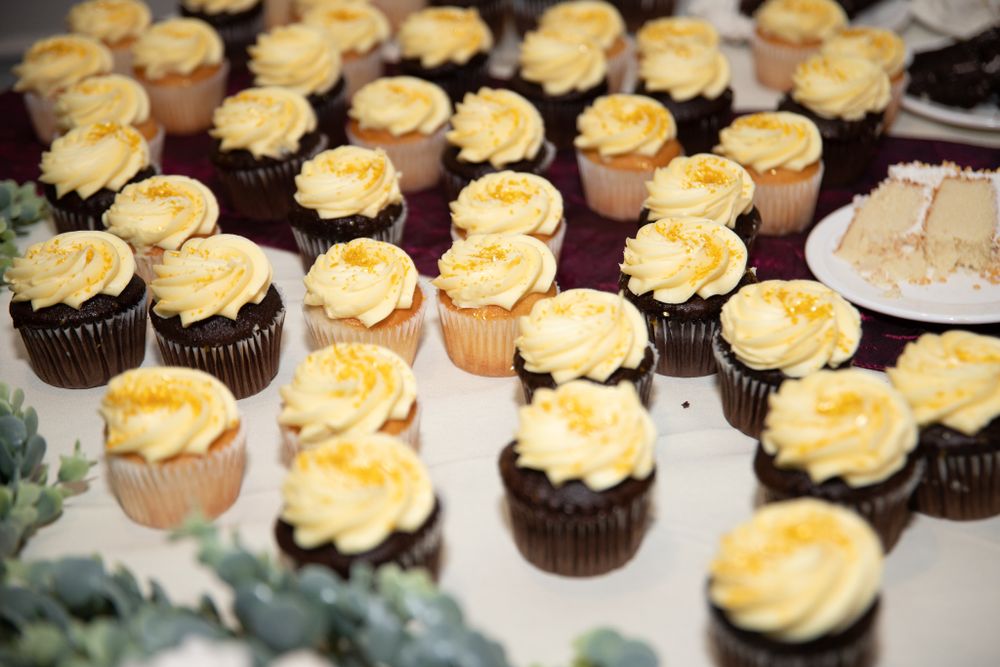 Yellow frosted cupcakes arranged on a dessert table at a wedding reception.
