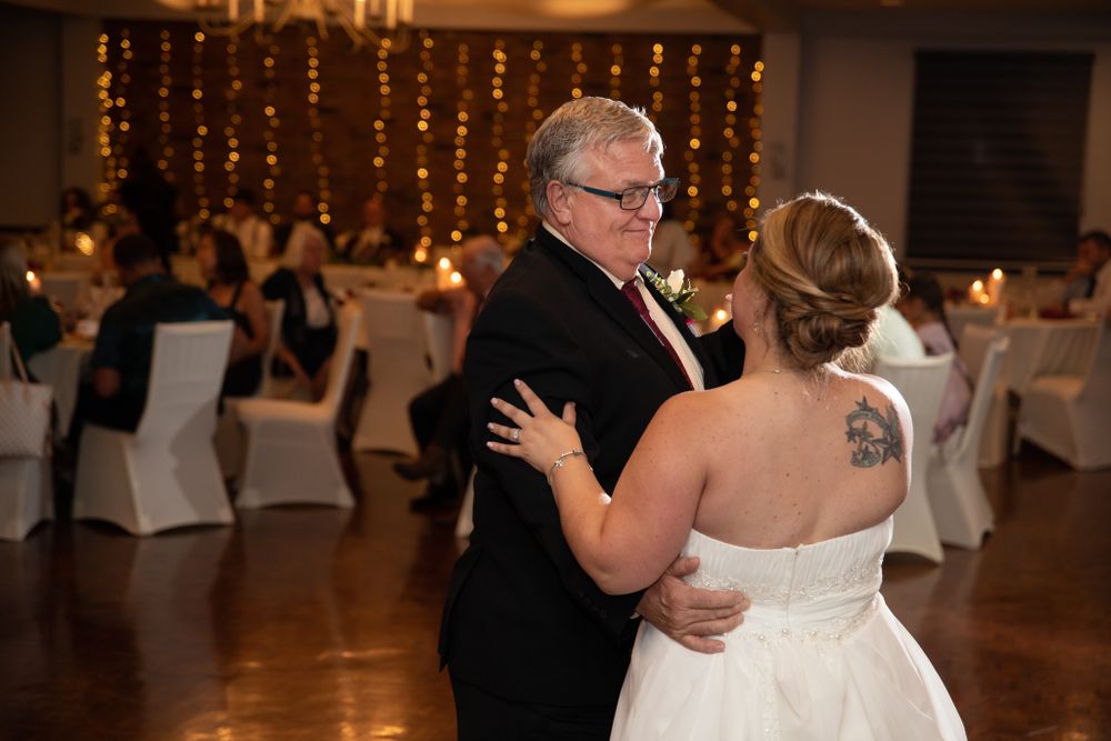 A tender dance moment at a wedding reception with string lights creating ambiance.
