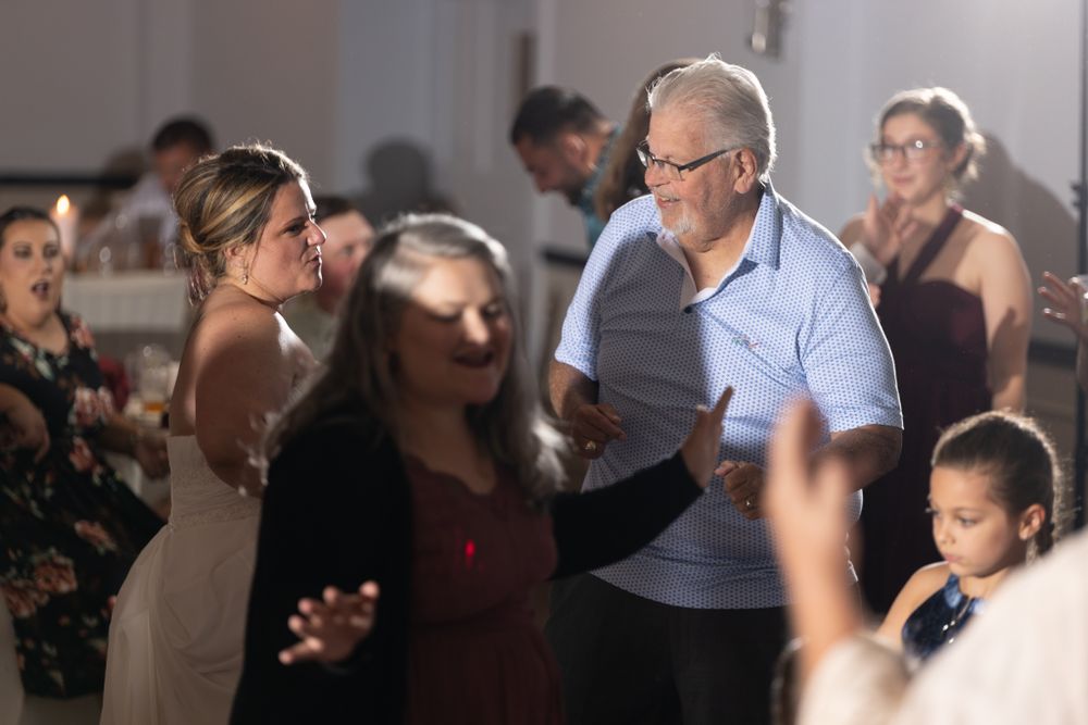 Wedding guests dance and celebrate on the reception dance floor.