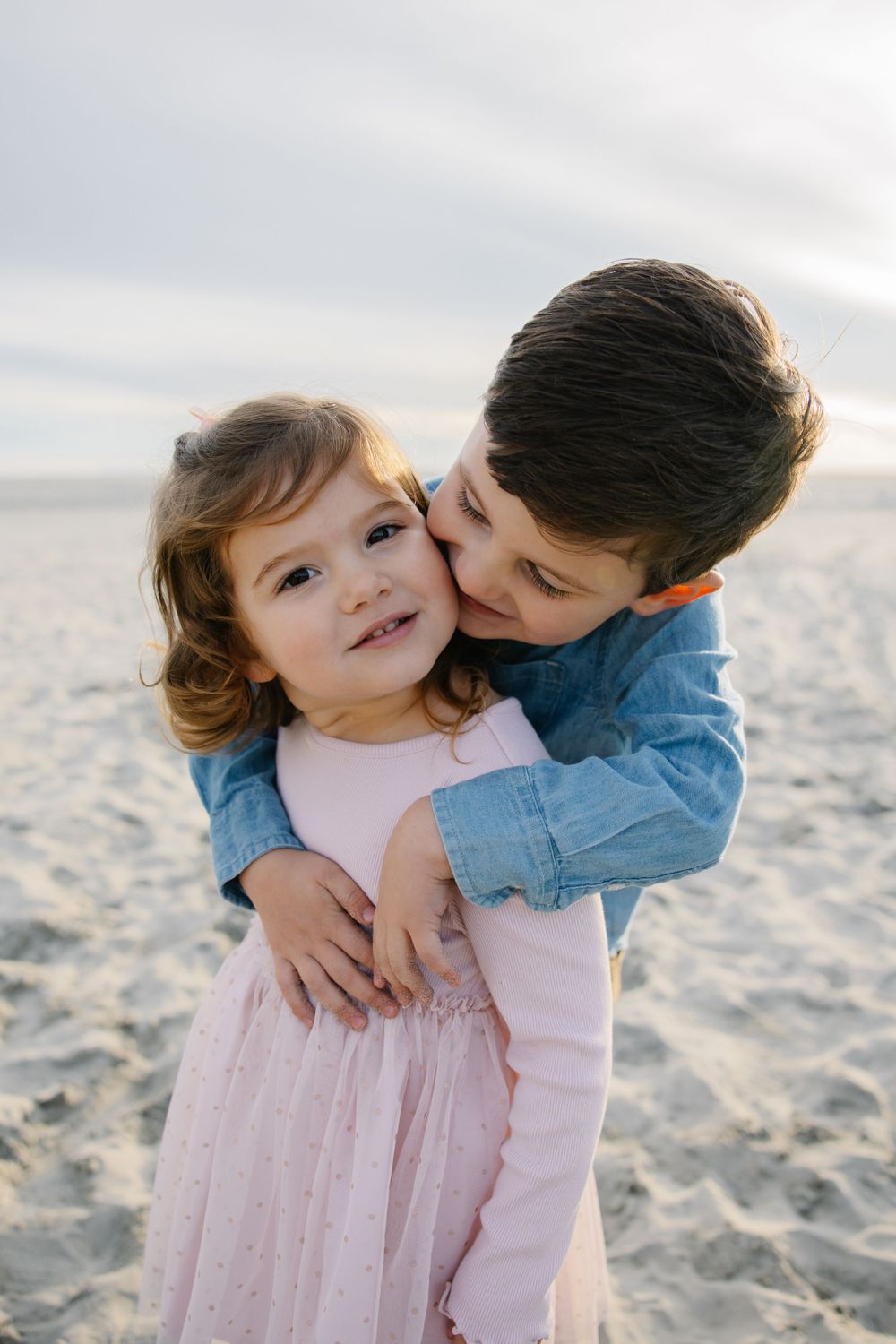 Sweet moment between parent and child hugging on beach.