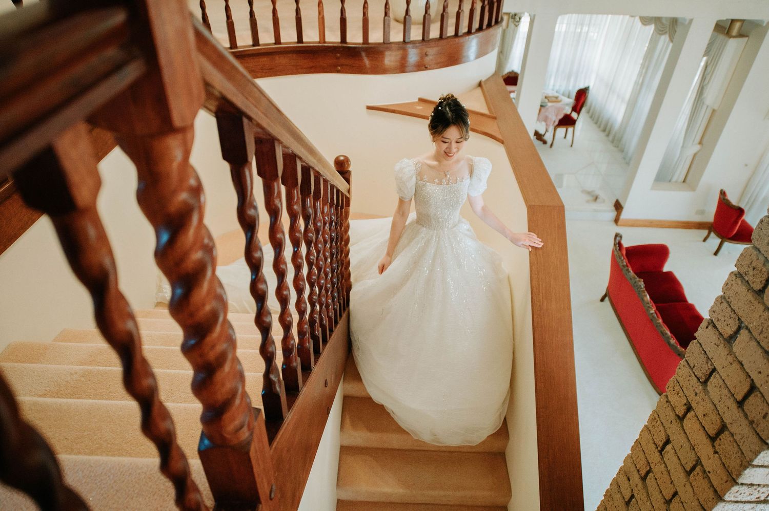 Wedding dress detail shot on spiral staircase with wooden banister.